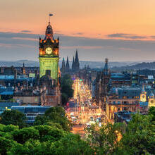 A clock tower at sunset in a busy city