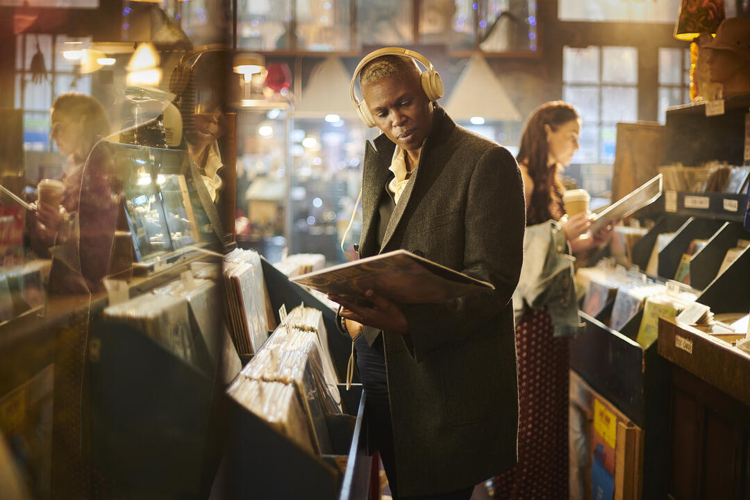 Man in a vintage vinyl shop holding a record