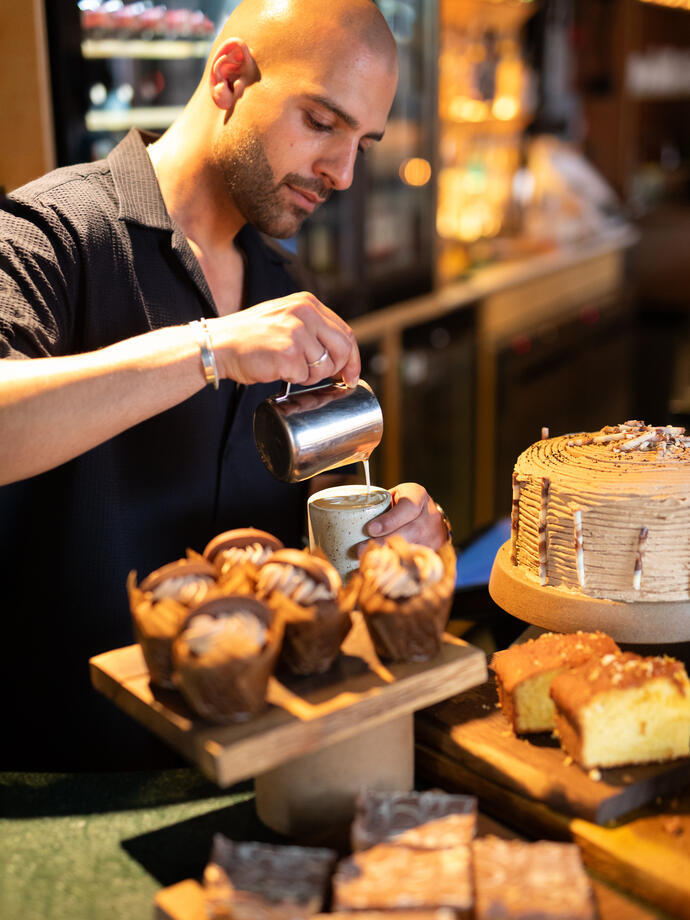 A Barista makes coffee at in a local cafe.