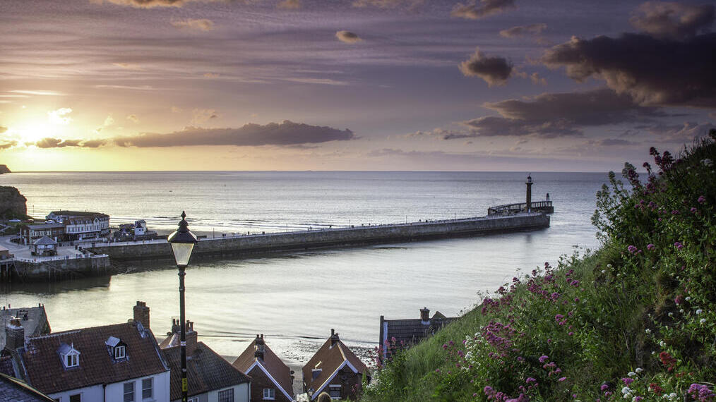 Two people on the steps of a cliff by the sea