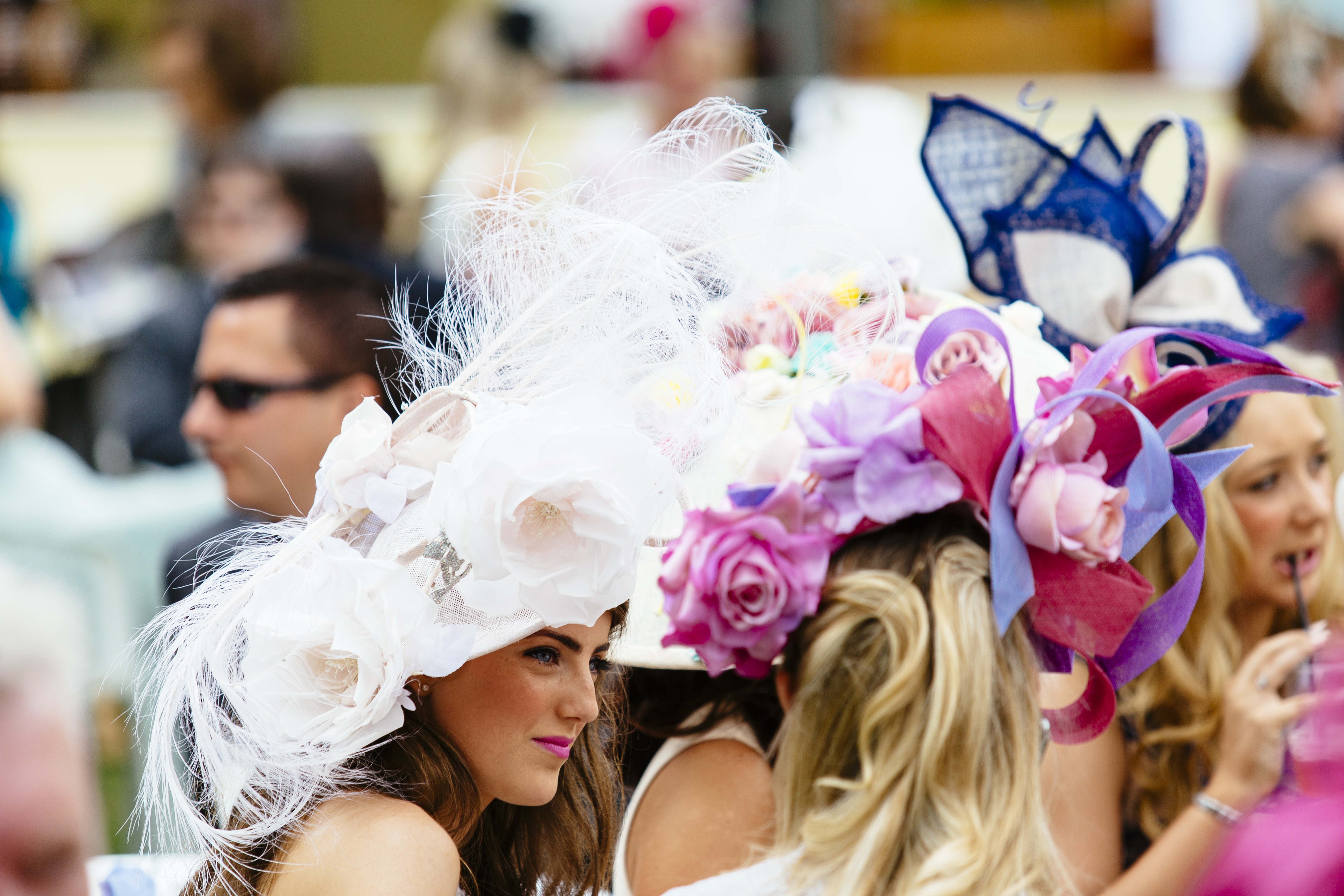 Personnes assistant à une course hippique, élégamment vêtues