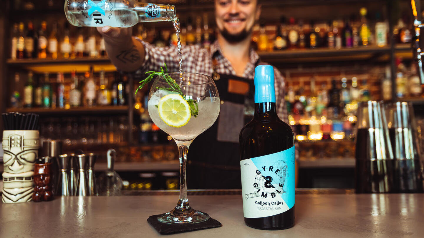 Un barman servant un cocktail à base de gin côtier au Gyre & Gimble à Norwich