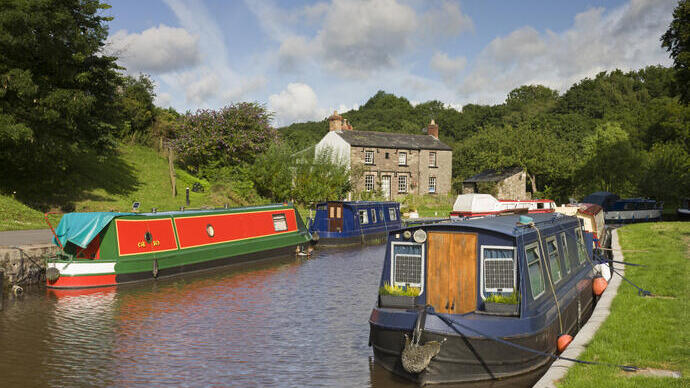 Narrowboats moored on a canal surrounded by grassy land