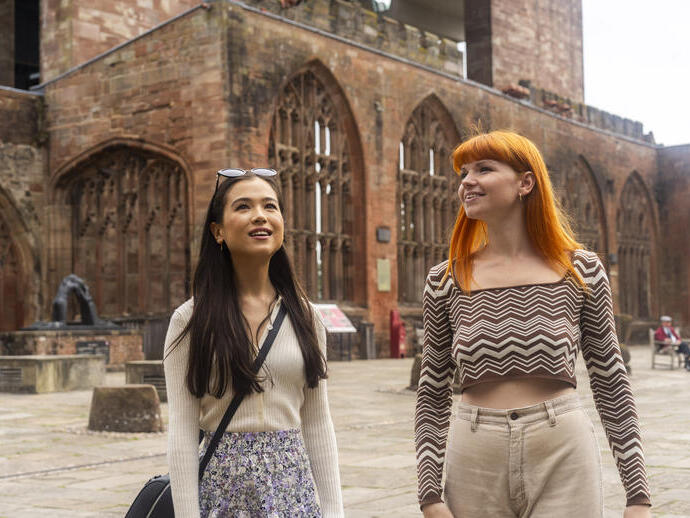 Dos mujeres exploran las ruinas dentro de los terrenos de una catedral