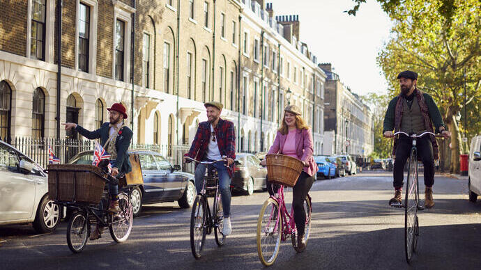 Four people on a guided tour on bicycles on a city road