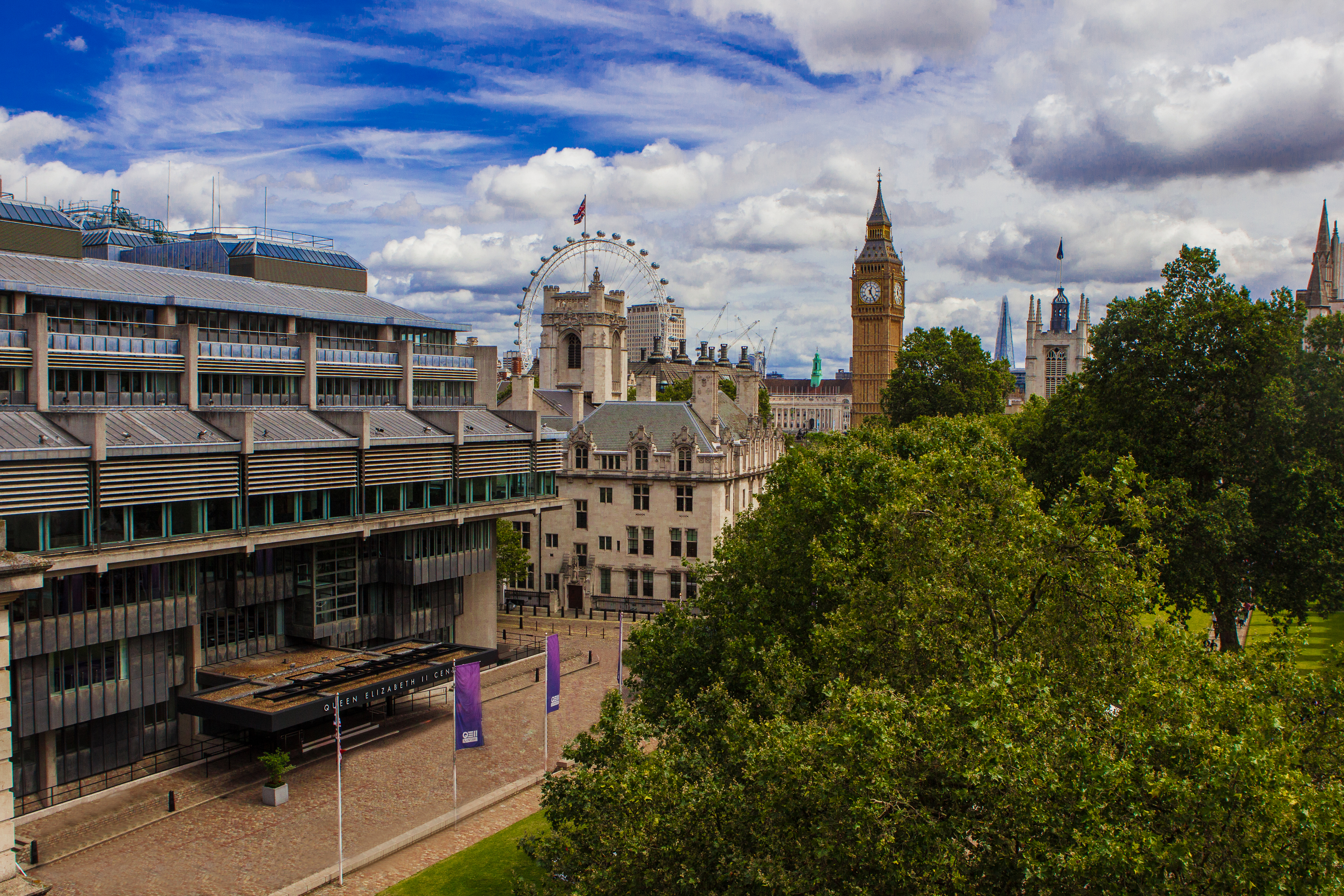 Wide shot of cityscape with clock tower and Ferris wheel