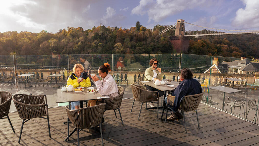 Friends enjoying tea and cake on a rooftop terrace