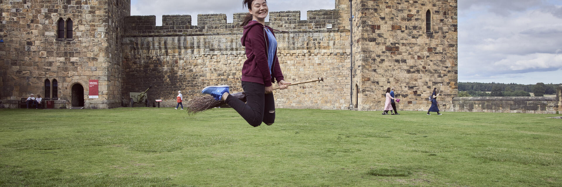 Femme sur un balai devant un château