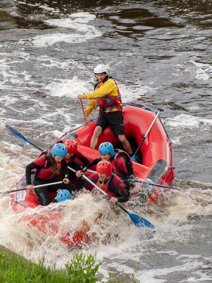 Un grupo de personas haciendo rafting con equipo de seguridad impermeable
