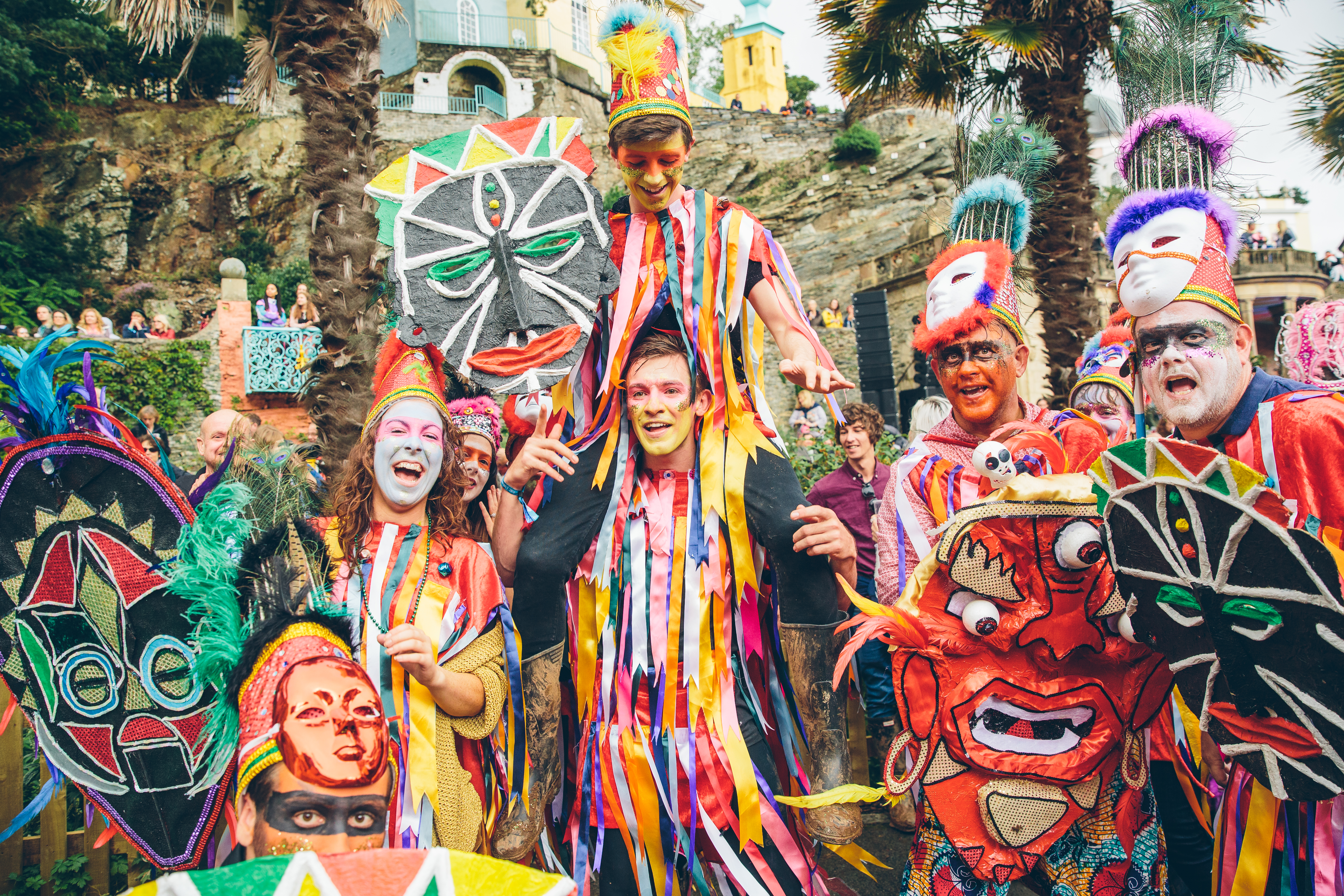 Gruppe von Darstellern in bunten Kostümen mit bemalten Gesichtern