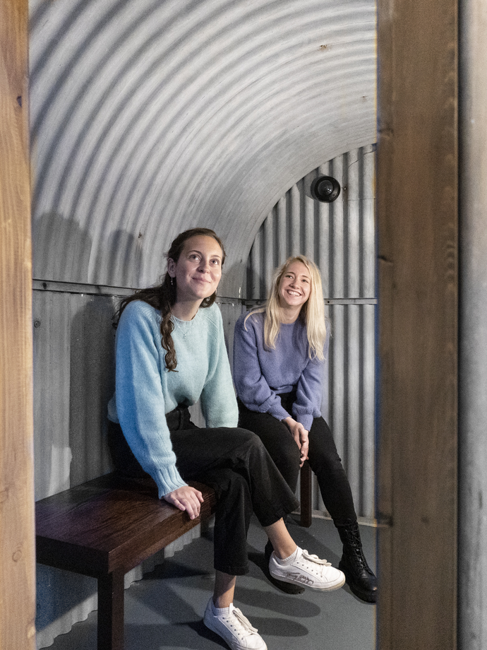 Two women sitting in a replica shelter in the Imperial War Museums, London
