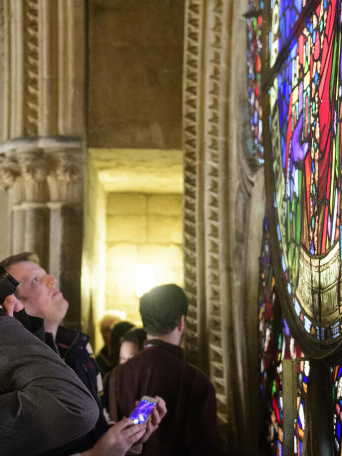 Un groupe de touristes visitant la cathédrale de Lincoln, admirant un vitrail
