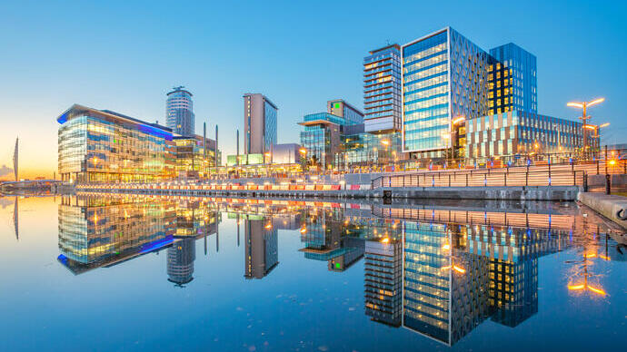 View of modern office buildings lit up and apartments in the city at twilight