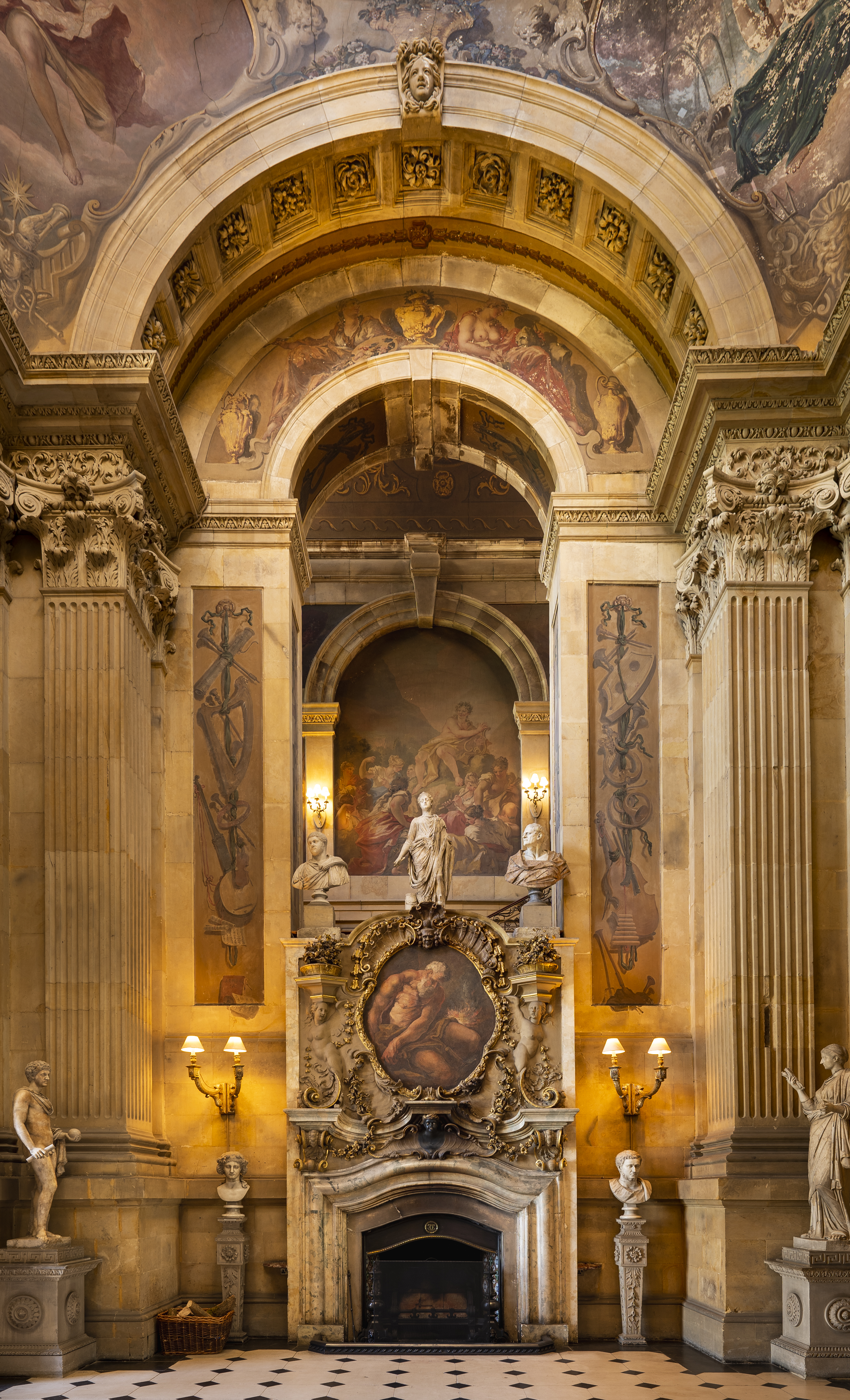 Interior shot of ornate fireplace and arch with painted ceiling and frescoes