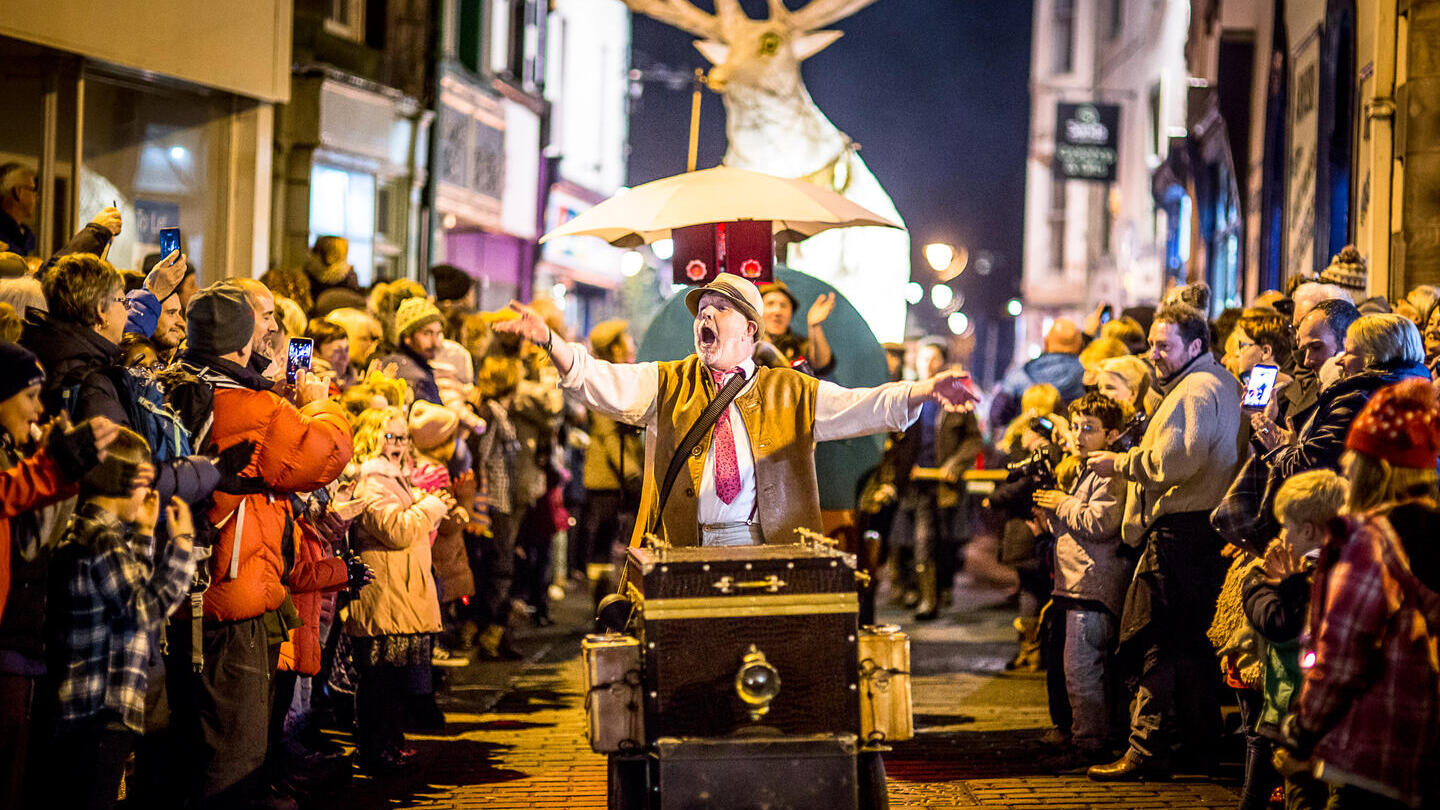 Des gens alignés des deux côtés de la rue regardent le Winter Droving