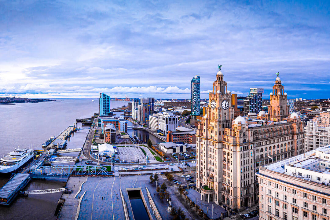 An aerial view of large city buildings overlooking a wide river.