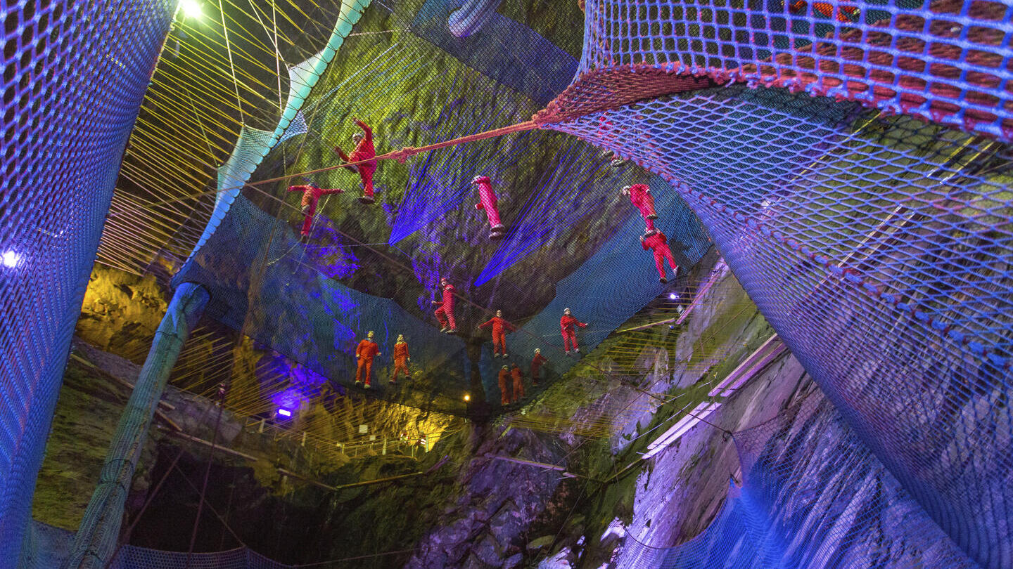 Groupe de personnes sautant sur des trampolines suspendus dans des cavernes profondes