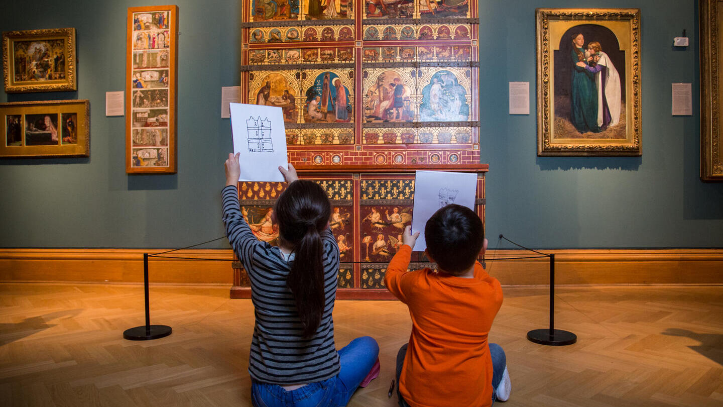 Two children seated on floor drawing museum exhibits