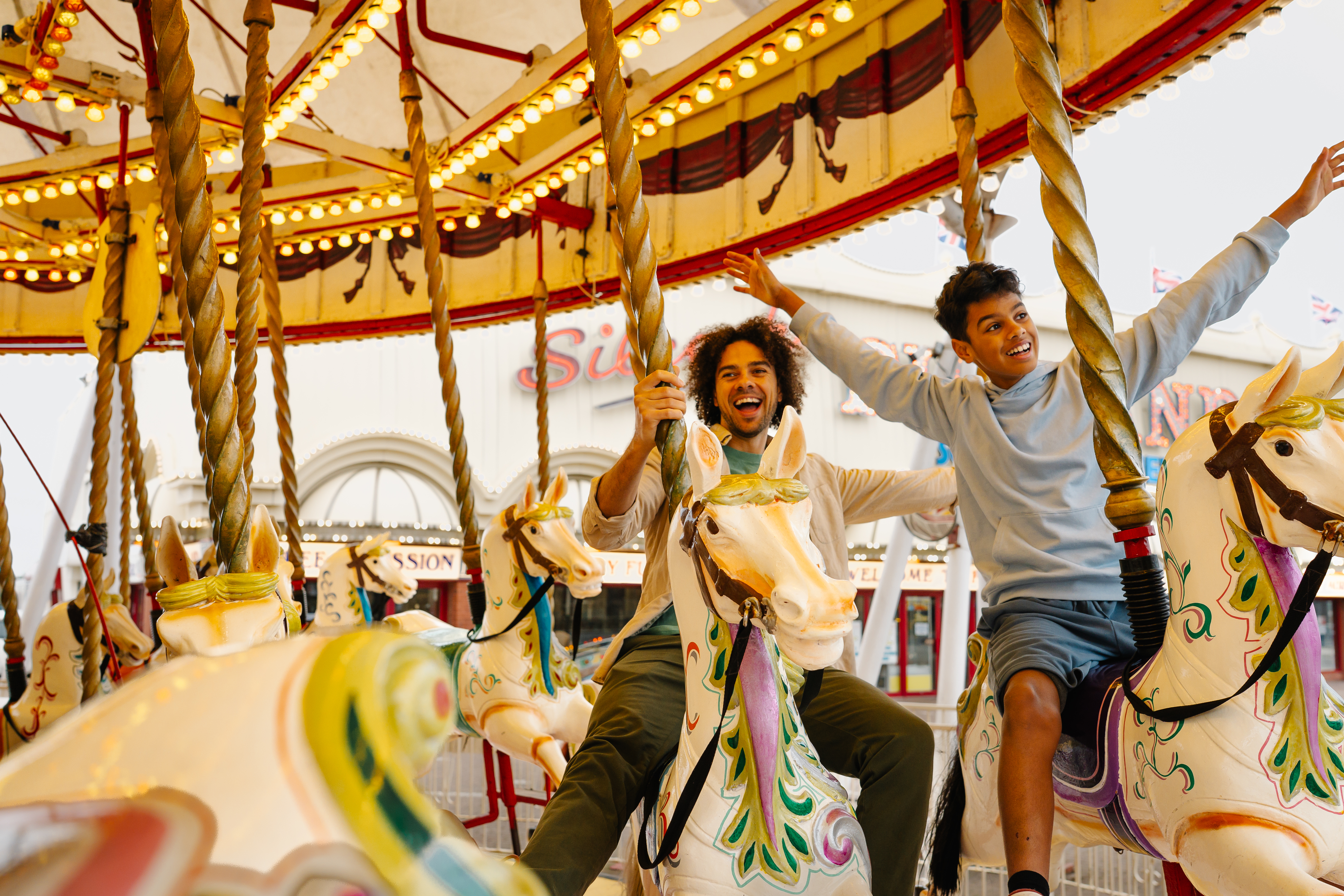 A father and son ride on a Carousel in an amusement park