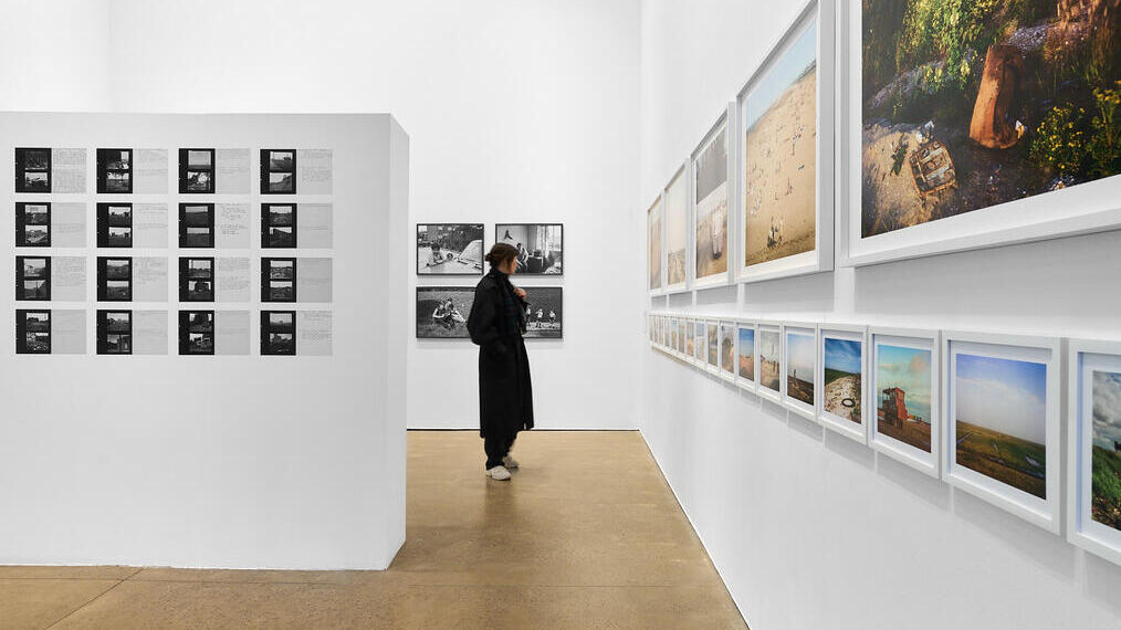 Una donna ammira le opere in una mostra fotografica.