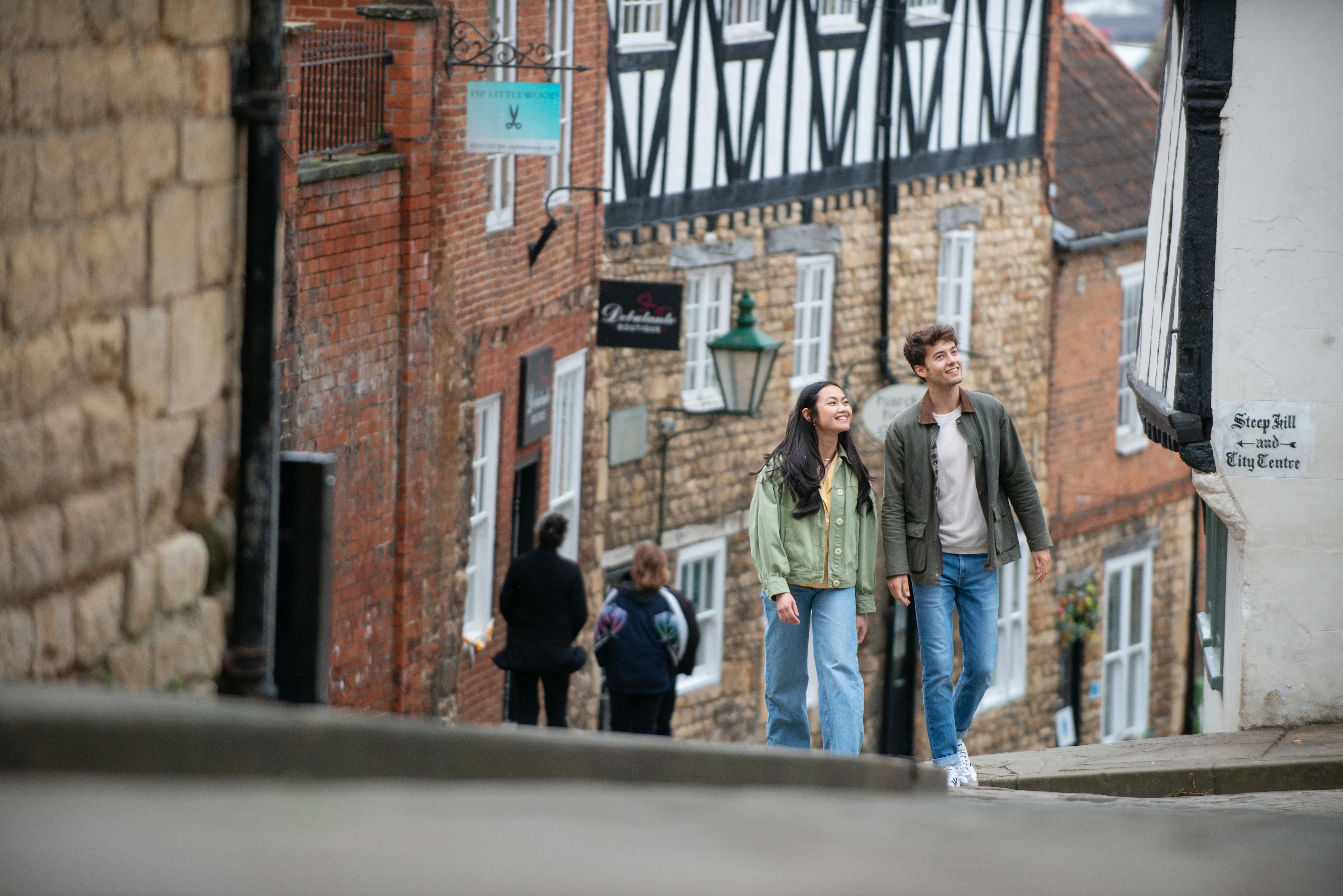 A woman and a man walk up a steep hill in a heritage City