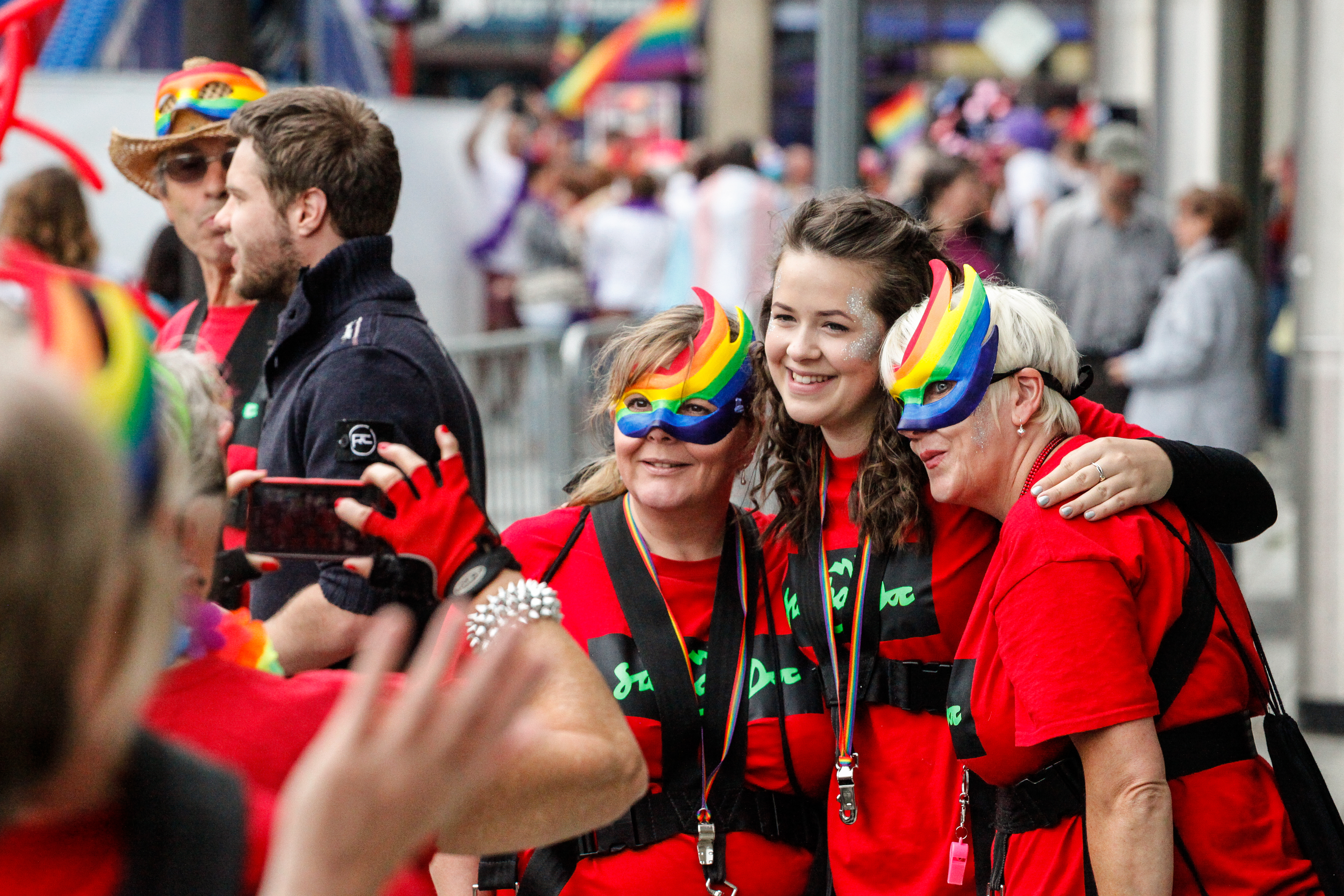 Frauen mit Regenbogenmasken feiern das Pride-Festival.