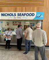 Un grupo de personas mirando marisco en un puesto de Great Yarmouth