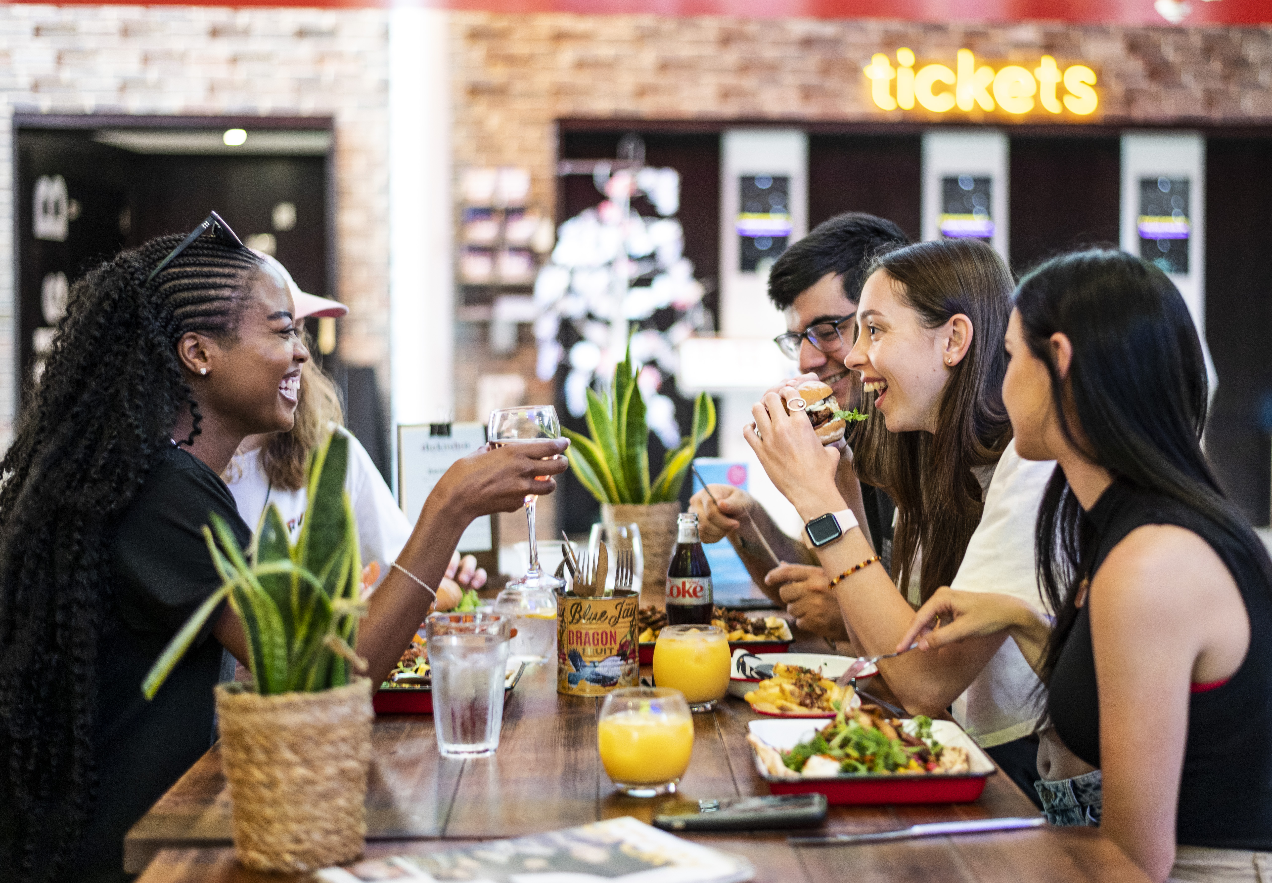 A group of people sitting on a bench eating food at the Storyhouse in Chester