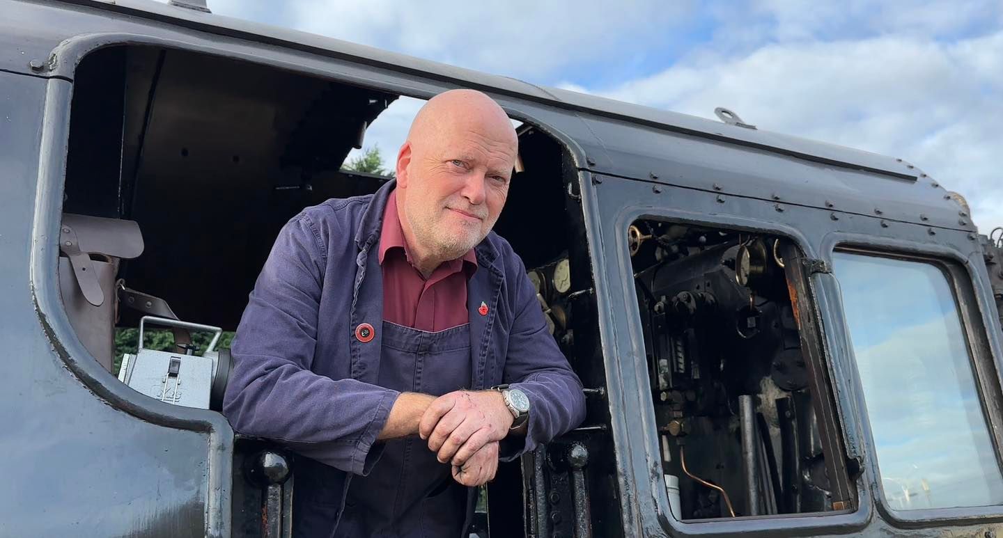 Maquinista asomando la cabeza por la ventanilla de un tren en Ecclesbourne Valley Railway