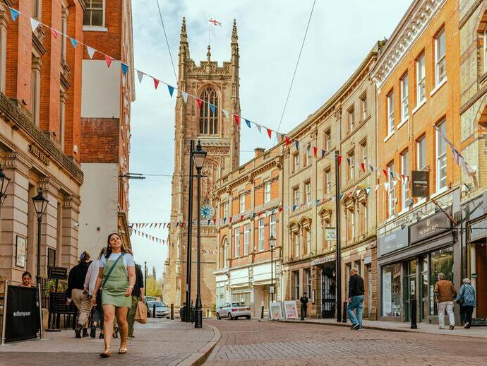 People walking down a street with a cathedral