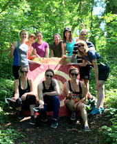 Un grupo de personas posando delante de una diana en una pista de lanzamiento de hachas en Bristol