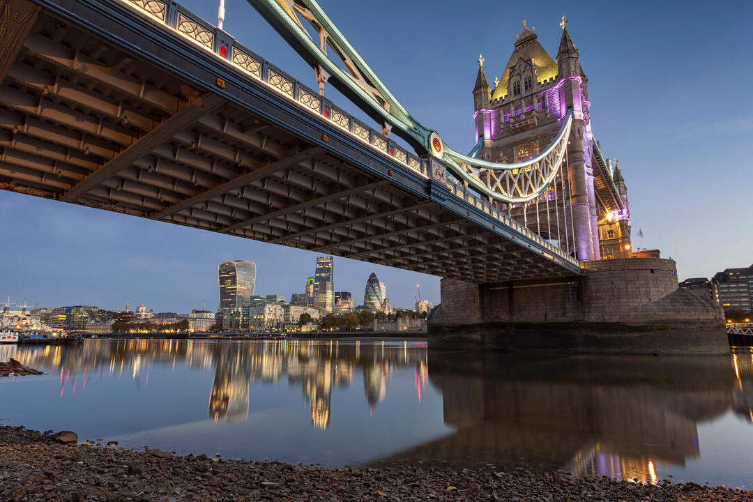 A bridge over a river in a city at dusk