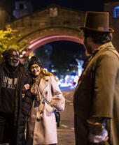 People listening to a tour guide at night as part of a ghost walk in Chester