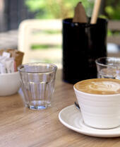 Cup of coffee latte on wooden table in a cafe.
