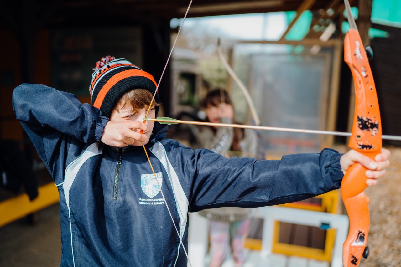 Ein Junge beim Bogenschießen in Heatherton World of Activities