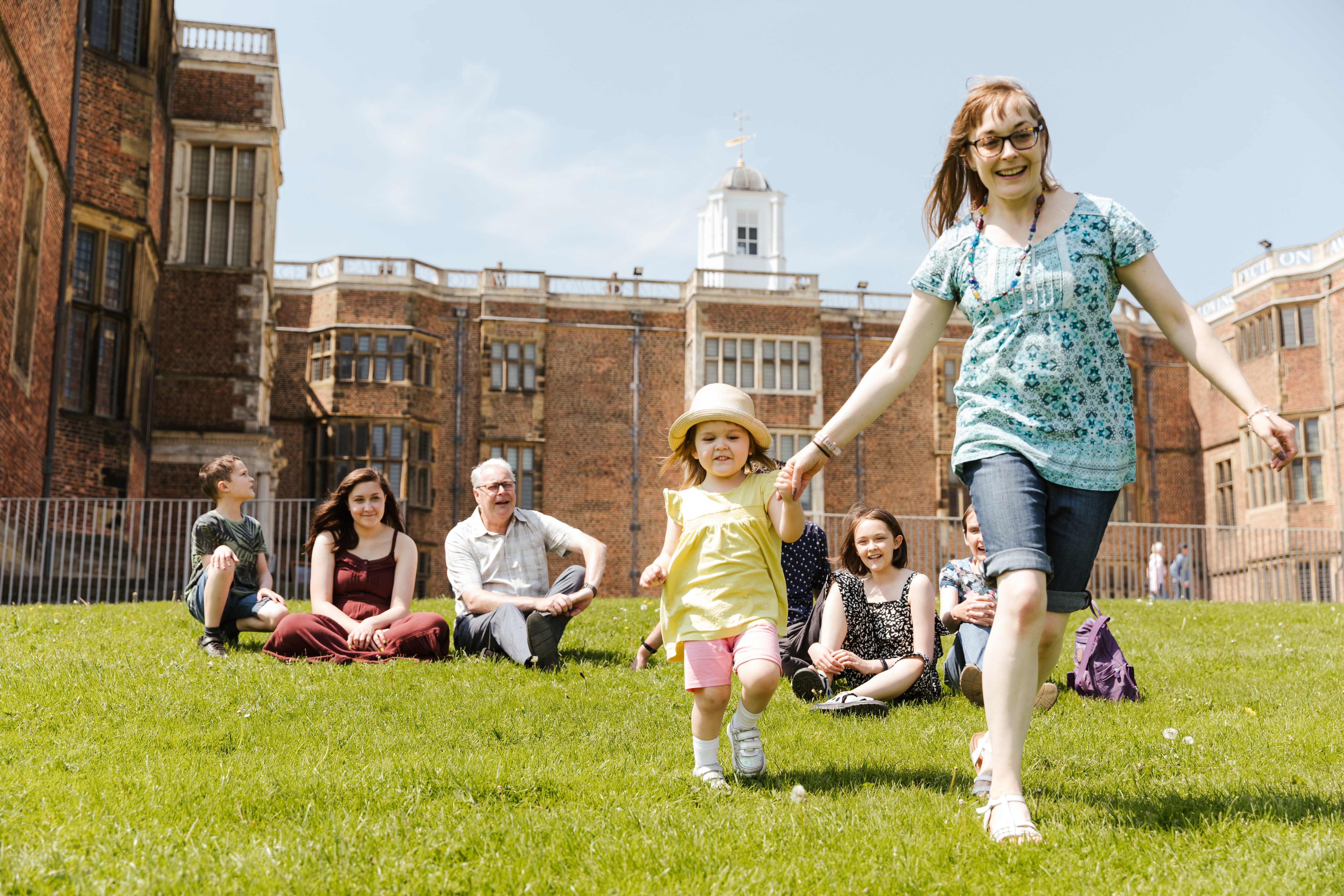 Children and parents sitting on the fields around Temple Newsam in Leeds