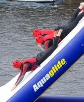 Gente deslizándose por un tobogán hasta el agua en el Liverpool Watersports Centre.