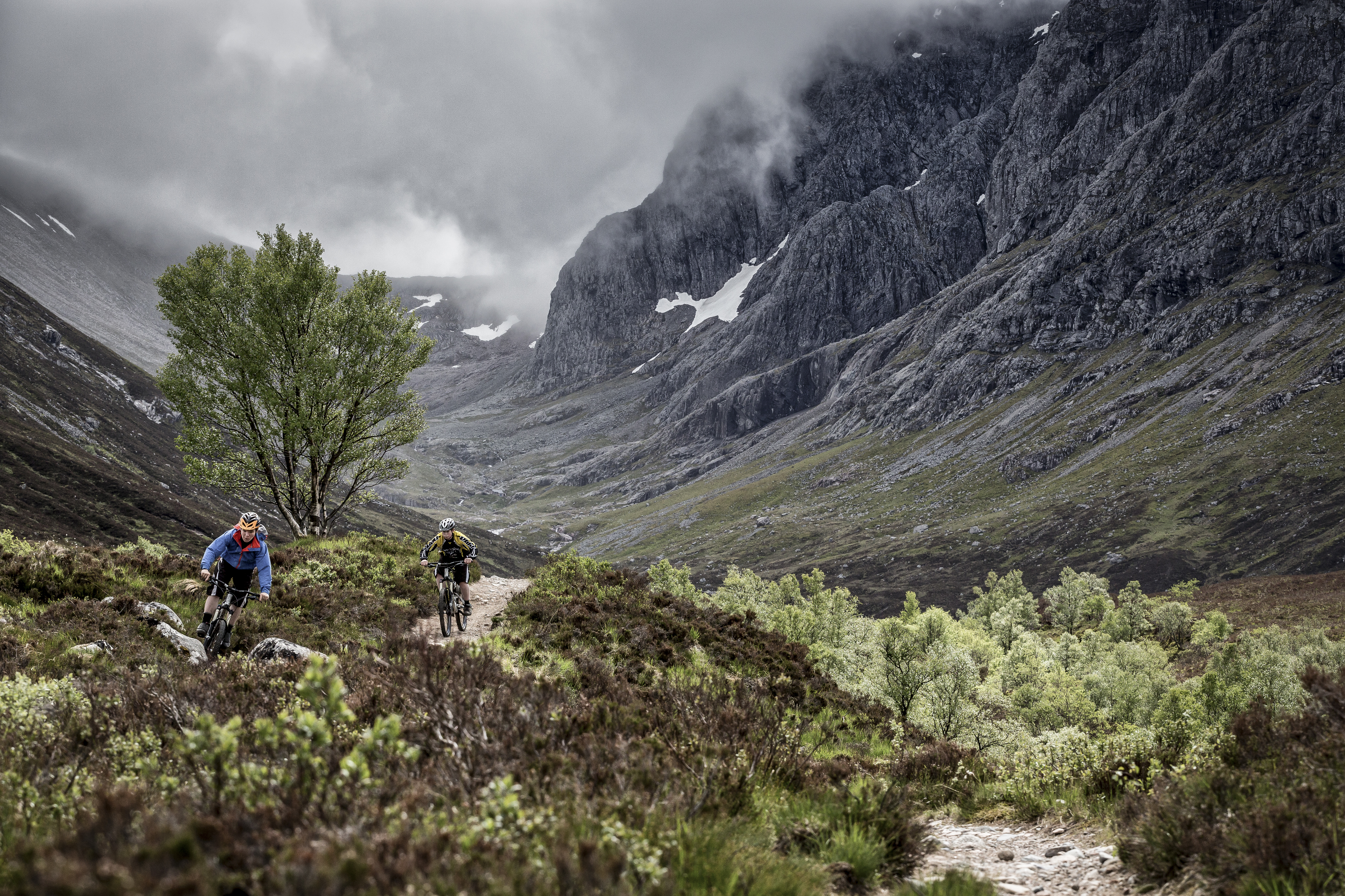 Two mountain bikers cycling on a trail going up a mountain