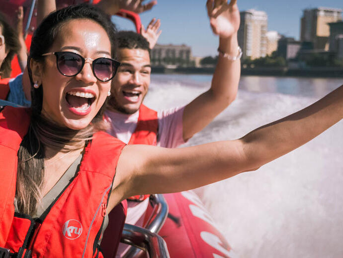 Close up of man young woman and man riding on speed boat on the Thames