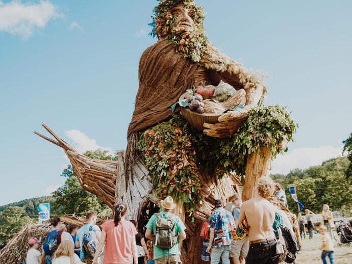 Group of people standing around large sculpture at a festival