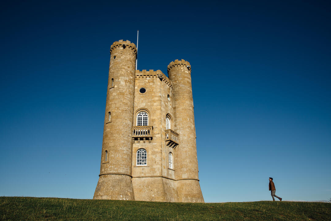 Man walking towards a turreted tower