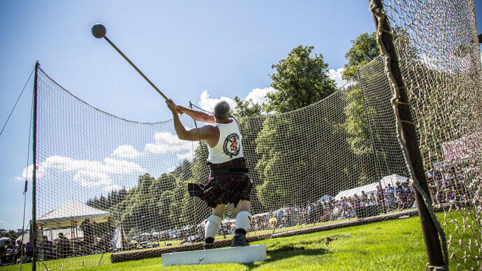 Inveraray Argyll Highland Games im Inveraray Castle. Mann in einem Kilt beim Hammerwurf.