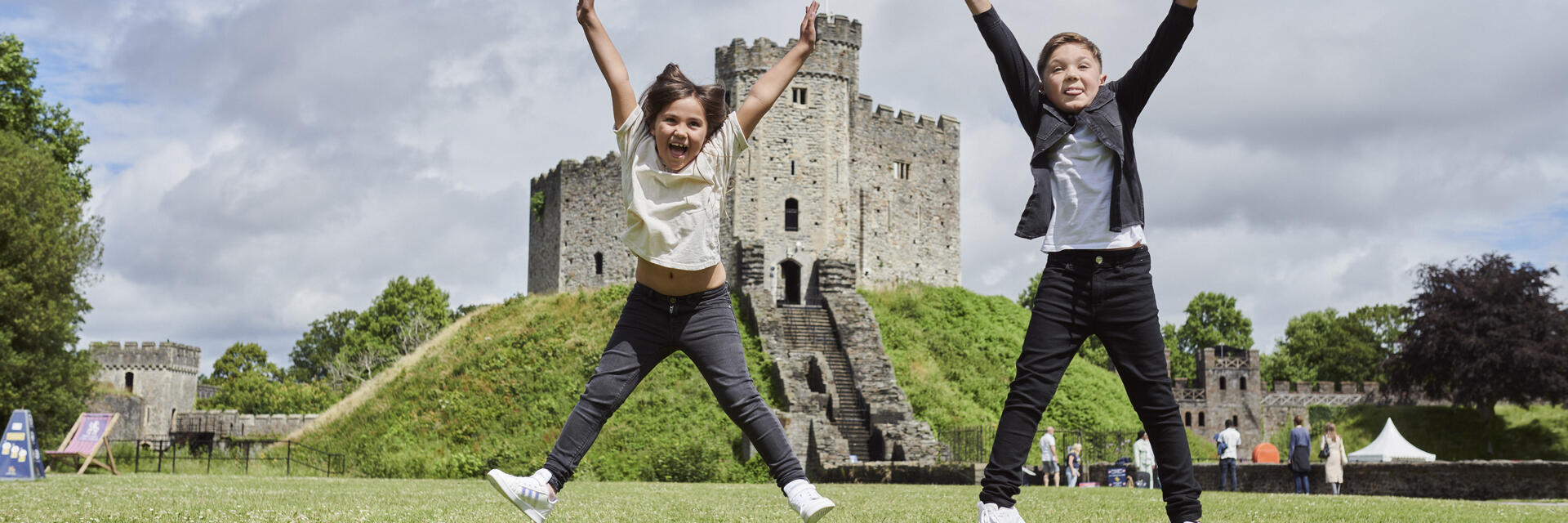 Deux enfants sautant devant un château.