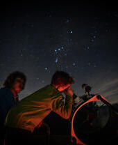 Child stargazing through telescope