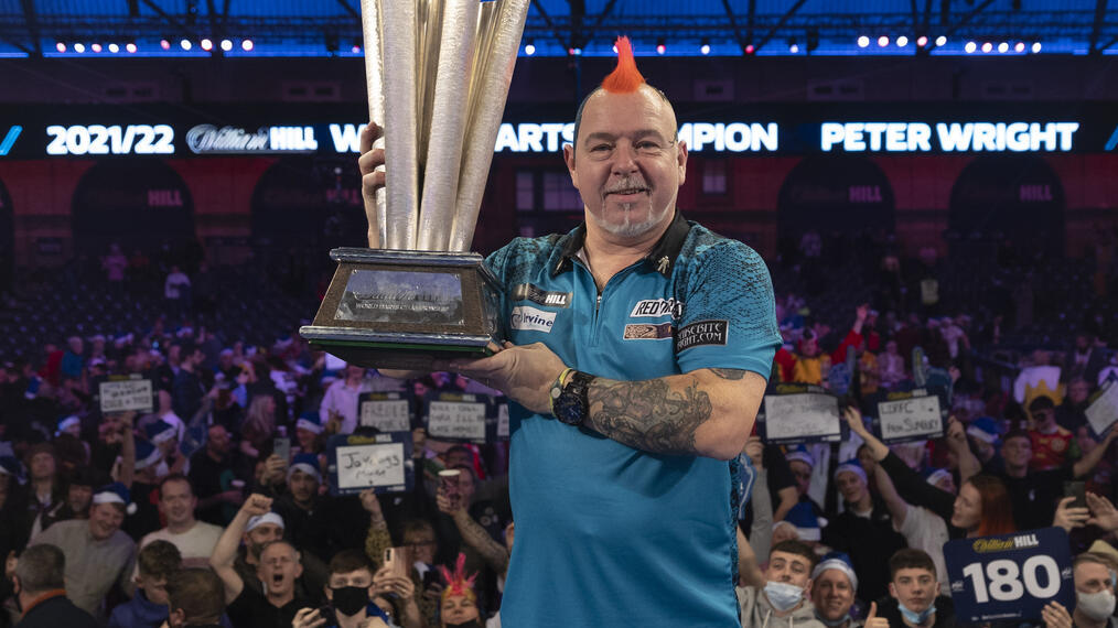 Homme tenant un trophée au championnat du monde de fléchettes