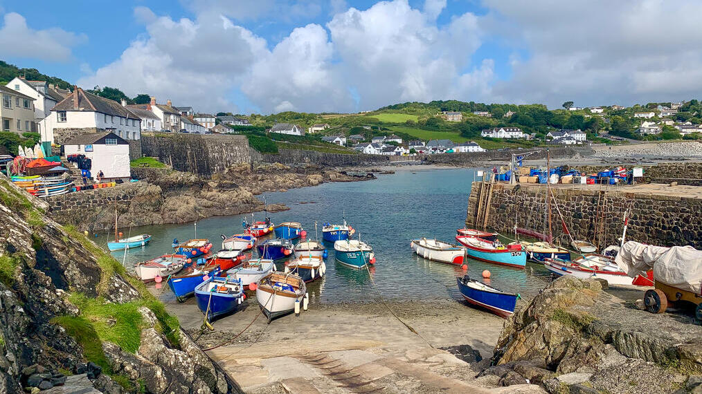 Ein malerisches Küstendorf mit vertäuten Booten und traditionellen Häusern.