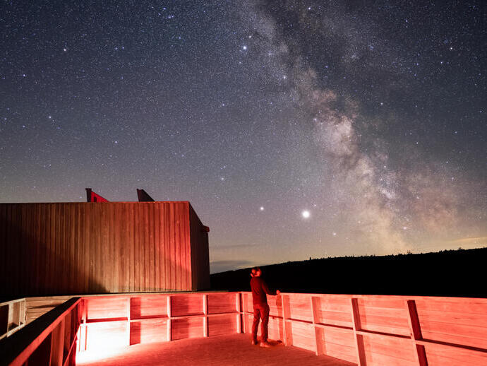 A person at the Kielder Observatory at night observing stars.