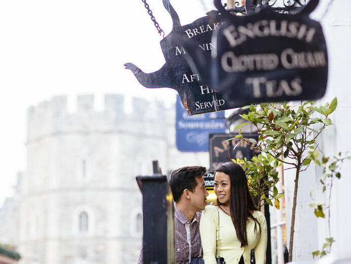 Couple in a street near tea shops and a castle in the background