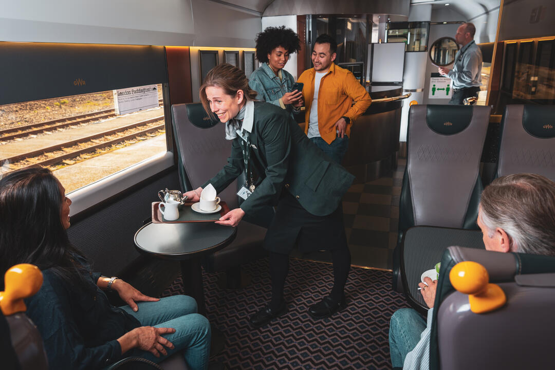 Personal del tren GWR atendiendo a los clientes a bordo de un tren GWR