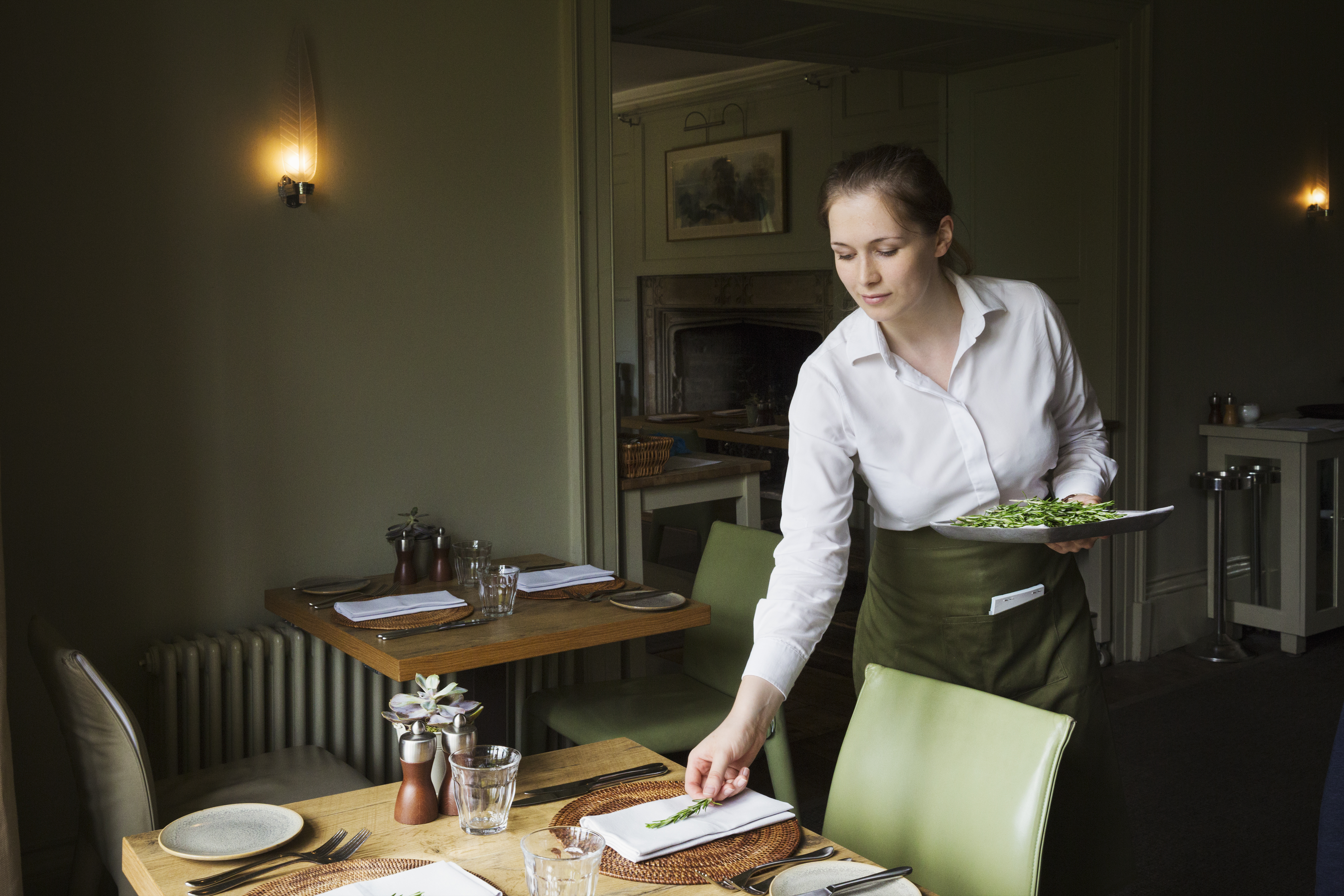 Woman setting a table in a restaurant